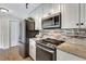 Contemporary kitchen featuring stainless steel appliances, light wood cabinets, and granite countertops at 3749 Mckay Creek Dr, Largo, FL 33770