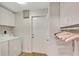 Laundry room with washer, dryer, storage cabinets, and access to the exterior at 3749 Mckay Creek Dr, Largo, FL 33770