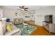 Cozy living room with hardwood floors, fan, and a view into the kitchen, perfect for entertaining at 3749 Mckay Creek Dr, Largo, FL 33770