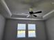 Bedroom featuring a modern ceiling fan, tray ceiling, and views of the green scenery at 3776 Maxwell Park Dr, Sun City Center, FL 33573