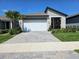 Charming single-Gathering home with a lush green yard, a paved driveway, and a two-car garage at 3776 Maxwell Park Dr, Sun City Center, FL 33573