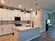 Modern kitchen featuring white cabinets, quartz countertops, and stylish pendant lighting at 3776 Maxwell Park Dr, Sun City Center, FL 33573