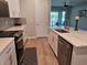 Kitchen with stainless steel appliances, quartz countertops and backyard view at 3776 Maxwell Park Dr, Sun City Center, FL 33573