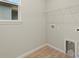 Bright laundry room features tile flooring, washer hookups, wire shelving, and a natural light window at 3776 Maxwell Park Dr, Sun City Center, FL 33573
