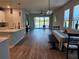 Open-concept living space with lake view, connecting kitchen and dining area at 3776 Maxwell Park Dr, Sun City Center, FL 33573