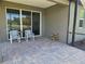 Cozy outdoor patio featuring comfortable seating and peaceful views of the backyard and lake at 3776 Maxwell Park Dr, Sun City Center, FL 33573