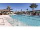 Community swimming pool with clear water, palm trees, lounge chairs, and nearby gazebo at 3776 Maxwell Park Dr, Sun City Center, FL 33573
