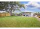 Expansive backyard with a spacious lawn, fire pit, and covered patio perfect for outdoor entertaining and relaxation at 3951 72Nd N St, St Petersburg, FL 33709