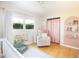 Bright Bedroom featuring a comfortable armchair, playful decor, and ample natural light from the large window at 3951 72Nd N St, St Petersburg, FL 33709