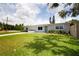 Charming single-story home featuring a well-manicured lawn, vibrant plants and a green door at 3951 72Nd N St, St Petersburg, FL 33709