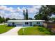 Charming single-story home featuring a well-manicured lawn, vibrant plants and a white mailbox and drive way at 3951 72Nd N St, St Petersburg, FL 33709