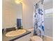 Well-lit bathroom with a white single sink vanity, white tiling, and a shower-tub combo at 4555 Hannah Ln, St Petersburg, FL 33709