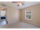 Neutral bedroom with a window, ceiling fan and doorway leading to bathroom at 4555 Hannah Ln, St Petersburg, FL 33709