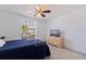 Comfortable bedroom with a ceiling fan, large window, and dresser with a TV at 4555 Hannah Ln, St Petersburg, FL 33709