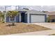 Charming blue home with a well-manicured lawn, palm tree, and a two-car garage at 4555 Hannah Ln, St Petersburg, FL 33709