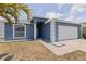 Charming home with a blue exterior, arched window, white trim and a two-car garage at 4555 Hannah Ln, St Petersburg, FL 33709