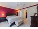 Cozy main bedroom featuring a large bed, accent wall, ceiling fan, and ensuite access at 4555 Hannah Ln, St Petersburg, FL 33709