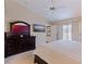 Bright main bedroom featuring a ceiling fan, neutral carpeting, and a large mirror at 4555 Hannah Ln, St Petersburg, FL 33709