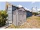 Exterior view of a gray storage shed next to a blue-grey house with white trim at 4555 Hannah Ln, St Petersburg, FL 33709