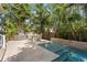 Outdoor kitchen & dining area next to luxurious swimming pool with decorative fountain feature at 4612 W Lowell Ave, Tampa, FL 33629