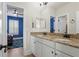 Bathroom with double vanity, granite countertops, with a blue accent bedroom visible through the doorway at 4612 W Lowell Ave, Tampa, FL 33629