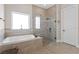 Bright bathroom featuring a tub and glass shower, plus decorative tile border accents at 4612 W Lowell Ave, Tampa, FL 33629