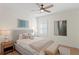 Bright bedroom with ceiling fan, gray headboard, side table with lamps, shuttered window at 4612 W Lowell Ave, Tampa, FL 33629