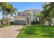Beautiful two-story home featuring a well-manicured lawn, a two car garage, and tropical landscaping at 4612 W Lowell Ave, Tampa, FL 33629