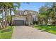 Beautiful two-story home featuring a well-manicured lawn, a two car garage, and tropical landscaping at 4612 W Lowell Ave, Tampa, FL 33629
