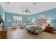 Serene main bedroom with bright blue walls, a ceiling fan, and natural light from the windows at 4612 W Lowell Ave, Tampa, FL 33629