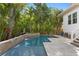 Stunning pool with a waterfall feature and tropical plants enhancing the privacy of the yard at 4612 W Lowell Ave, Tampa, FL 33629