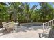 Inviting backyard pool area with a travertine patio, seating, and lush tropical landscaping at 4612 W Lowell Ave, Tampa, FL 33629