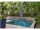 Swimming pool with basketball hoop, travertine deck, and lush landscaping at 4612 W Lowell Ave, Tampa, FL 33629