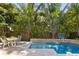 Stunning pool area with tropical landscaping, a basketball hoop, and patio seating at 4612 W Lowell Ave, Tampa, FL 33629