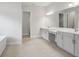 Bright bathroom featuring dual vanities with gray cabinets and neutral tile flooring at 4630 Cedar Fog Ct Dr, Valrico, FL 33596