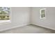 Bright bedroom featuring two windows and neutral carpeting at 4630 Cedar Fog Ct Dr, Valrico, FL 33596
