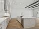 Modern kitchen with white cabinetry, stainless steel appliances, an island, and views of the living area at 4630 Cedar Fog Ct Dr, Valrico, FL 33596