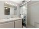 Well-lit bathroom features a vanity, mirror with lighting, and a shower with a glass door and tile surround at 4908 38Th S Way # 206, St Petersburg, FL 33711
