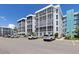 Multi-unit condo complex shows architectural design with ample parking, landscaping, and a blue painted accent wall at 4908 38Th S Way # 206, St Petersburg, FL 33711