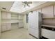 Functional kitchen with white appliances, tile flooring, a skylight, and ample cabinet space for storage at 4908 38Th S Way # 206, St Petersburg, FL 33711