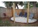 Cozy backyard seating area with chairs on a white gravel base, bordered by a wooden fence and lush landscaping at 5205 98Th N Ter, Pinellas Park, FL 33782