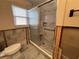 This bathroom features a modern shower with glass doors and neutral tile, presenting a partially renovated space at 5445 Manatee Point Dr, New Port Richey, FL 34652