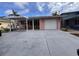 Charming pink single-story home featuring a covered carport and white garage door, complemented by tropical palm tree accents at 5445 Manatee Point Dr, New Port Richey, FL 34652