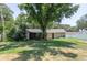 Beautiful backyard showcasing green lawn, privacy fence, cozy patio, and home exterior with mature trees at 606 Brentwood Pl, Brandon, FL 33511