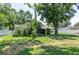 Scenic backyard view with mature trees, privacy fencing, a cozy patio, and the house exterior at 606 Brentwood Pl, Brandon, FL 33511