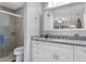 The bathroom features a large mirror, granite countertop, white cabinetry, and tiled walk-in shower at 606 Brentwood Pl, Brandon, FL 33511