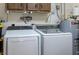 Laundry room equipped with a washer, dryer, and water heater; cabinets above for storage at 606 Brentwood Pl, Brandon, FL 33511