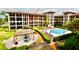 Beautiful condo exterior shows the pool and outdoor pergola seating area, with tropical plants and outdoor furniture at 6150 Gulfport S Blvd # 302, Gulfport, FL 33707