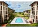Exterior view shows the condo buildings, pool with lounge chairs and golf course in the distance at 6150 Gulfport S Blvd # 302, Gulfport, FL 33707
