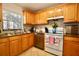 Kitchen featuring wooden cabinets, stainless steel appliances, granite countertops, and tile floors at 6150 Gulfport S Blvd # 302, Gulfport, FL 33707